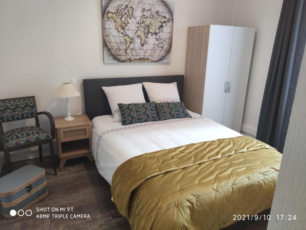 a bedroom with a bed and a map on the wall at Du Guesclin Appart in Saint-Brieuc