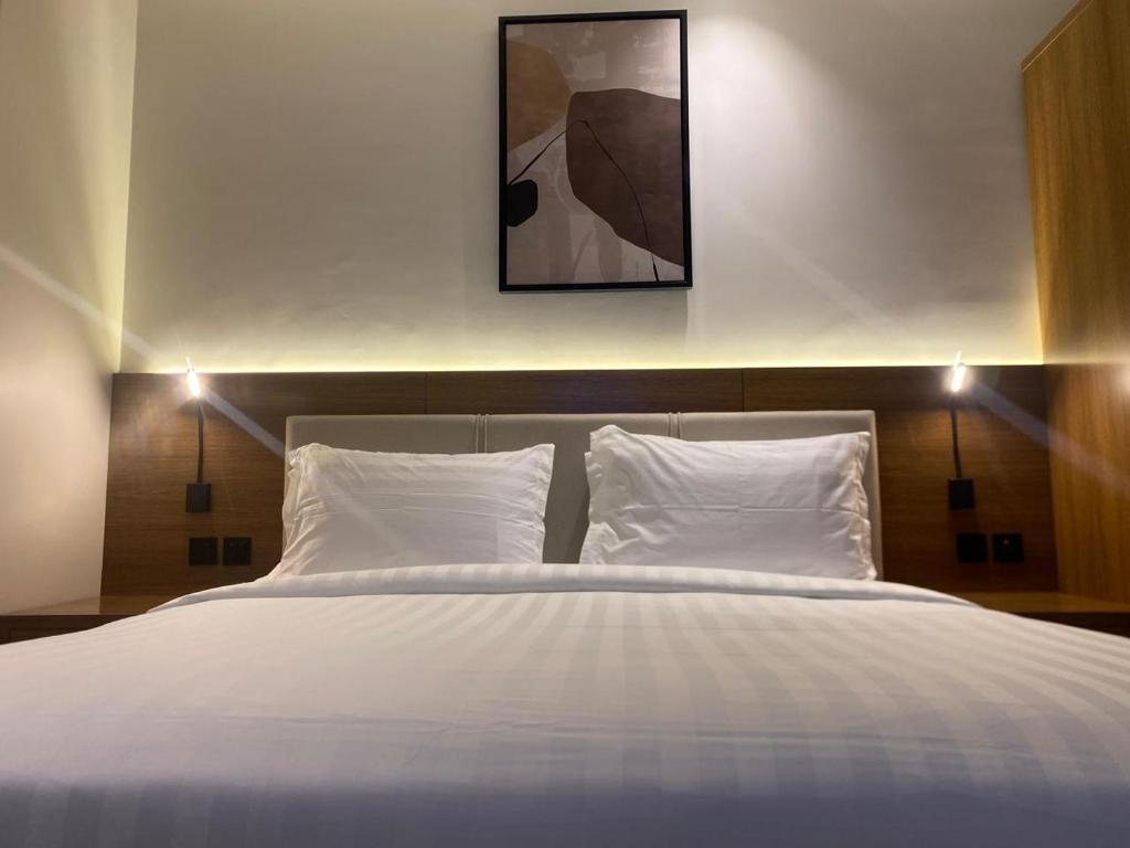 een bed met twee kussens en een foto erboven bij فندق اونيسن الشاطئ Onsen Hotel in Dammam