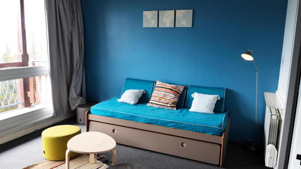 une chambre bleue avec un canapé et un mur bleu dans l'établissement Résidence Thuria - 3 Pièces pour 8 Personnes MAE-2194, à Arc 1800