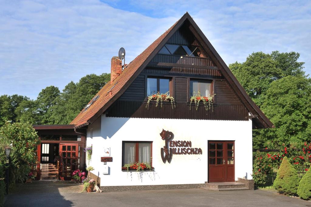 a white building with a brown roof at Pension Willischza in Burg