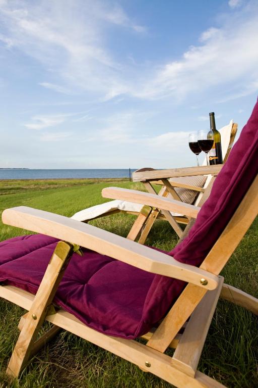 a picnic table and chairs sitting on the grass at Anker's Hörn - Hotel & Restaurant auf der Hallig Langeness in Langeneß