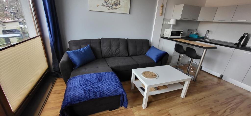 a small living room with a couch and a table at ApartMorze Apartamenty na Leśnej in Jastarnia