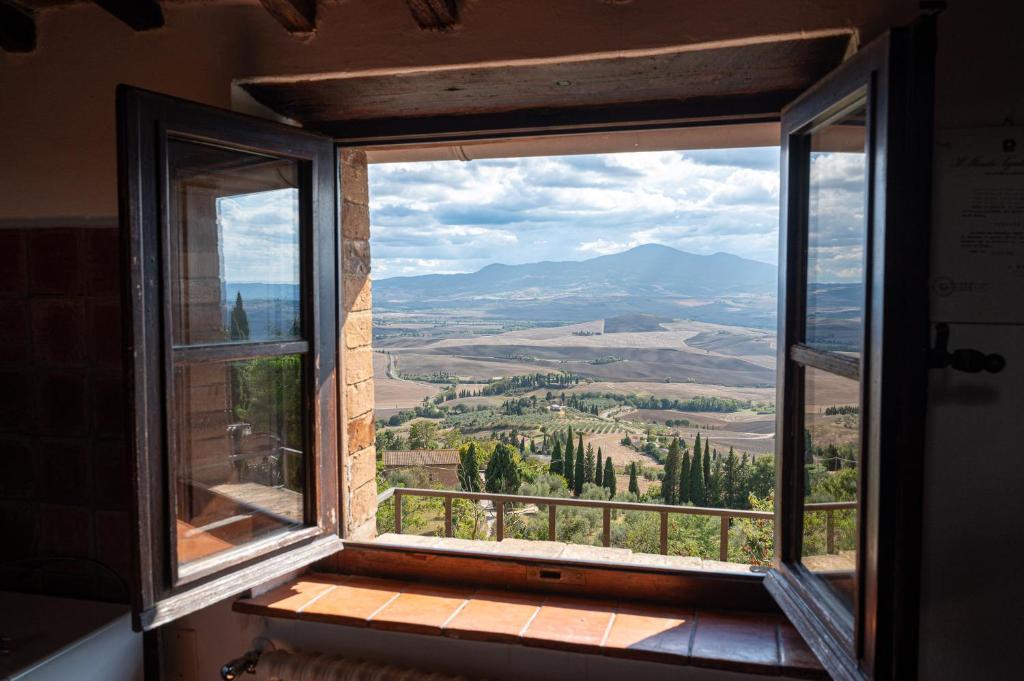 an open window with a view of a mountain view at Artistica Pienza - Breathtaking Val d'Orcia View in Pienza