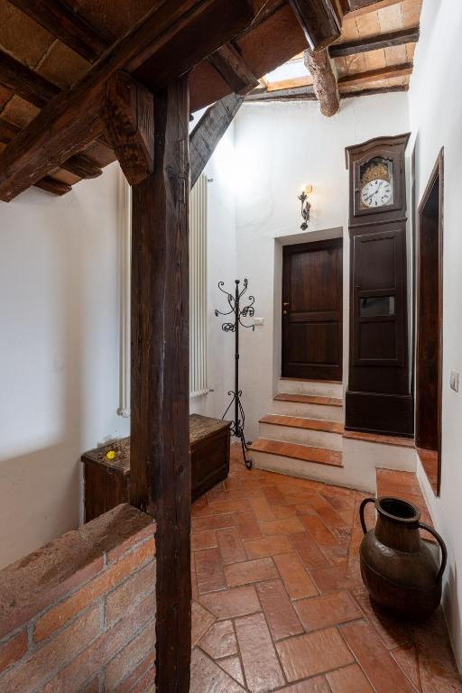 a hallway with a clock on the wall and a door at Artistica Pienza - Breathtaking Val d'Orcia View in Pienza