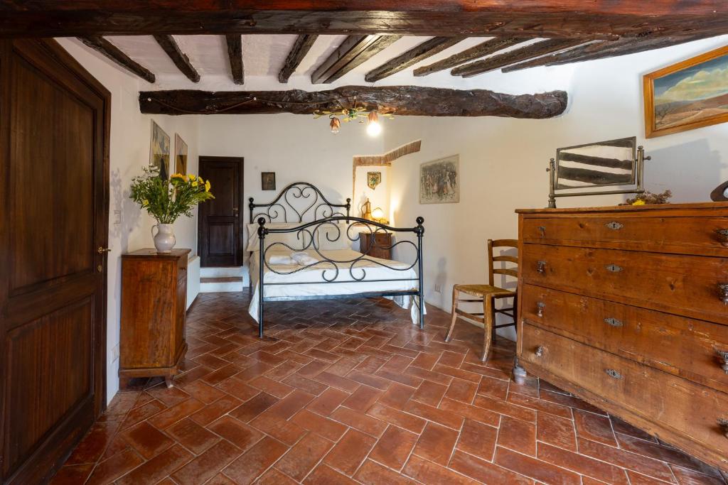 a bedroom with a bed and a dresser at Artistica Pienza - Breathtaking Val d'Orcia View in Pienza