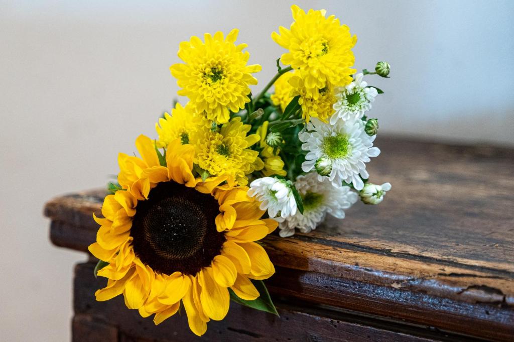 a bouquet of yellow and white flowers sitting on a table at Artistica Pienza - Breathtaking Val d'Orcia View in Pienza