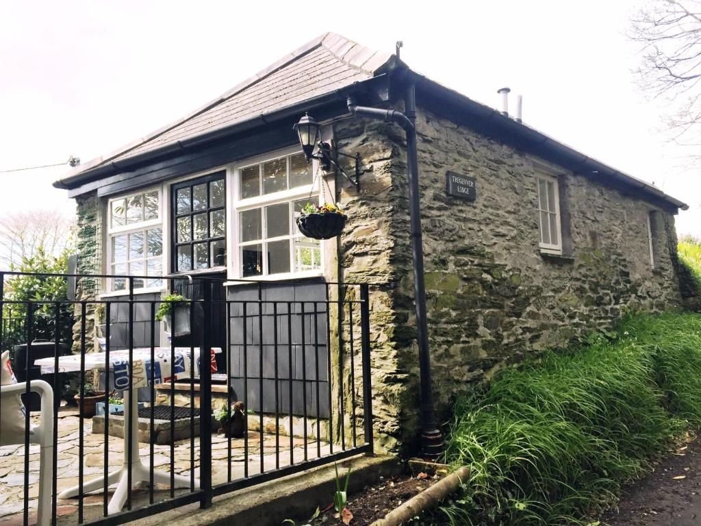 an old stone house with a gate at Tregenver Lodge in Falmouth