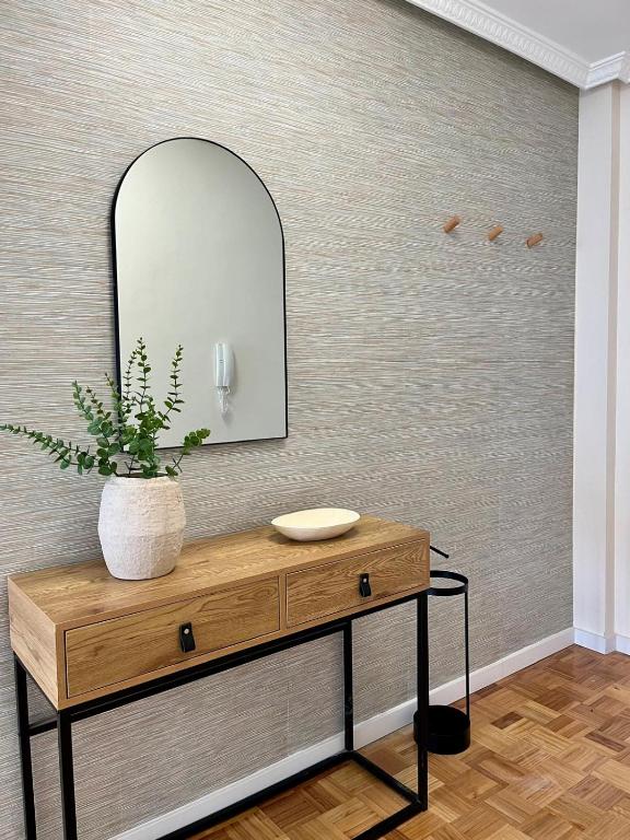 a bathroom with a vanity with a mirror and a plant at Otto's Home Horizonte in Lastres