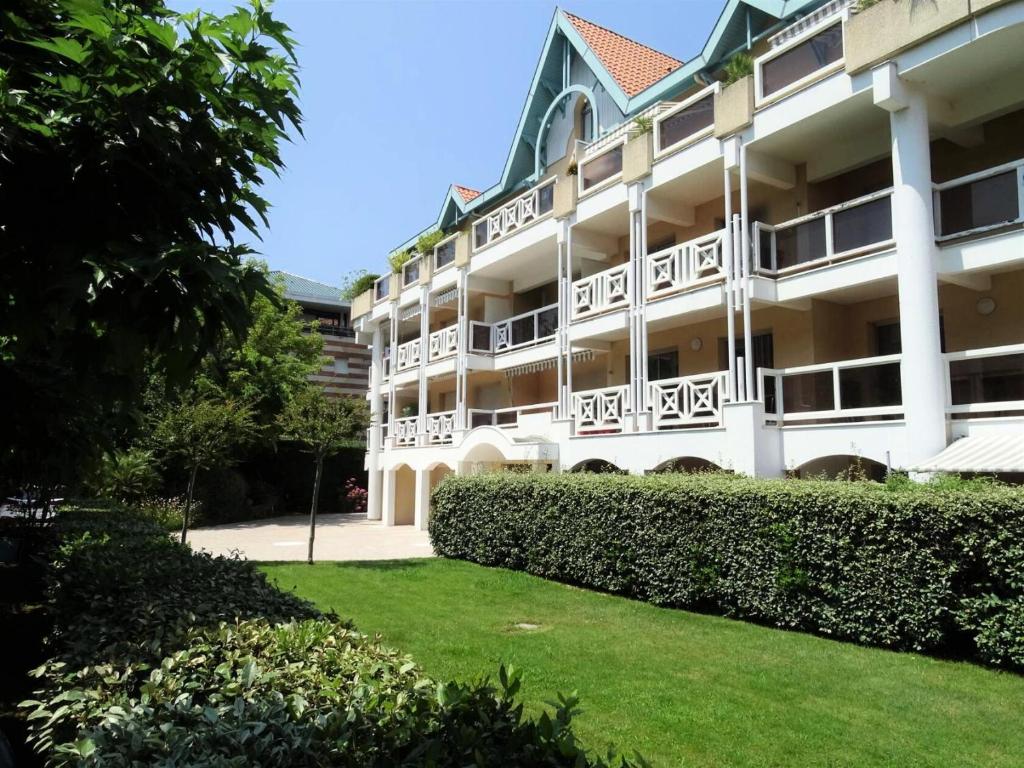 un grand bâtiment blanc avec un toit vert dans l'établissement Résidence Clos St Arnaud - Arcachon – Charmant appartement à 300 m de la plage, dans le quartier Ville de Printemps MAE-7074, à Arcachon