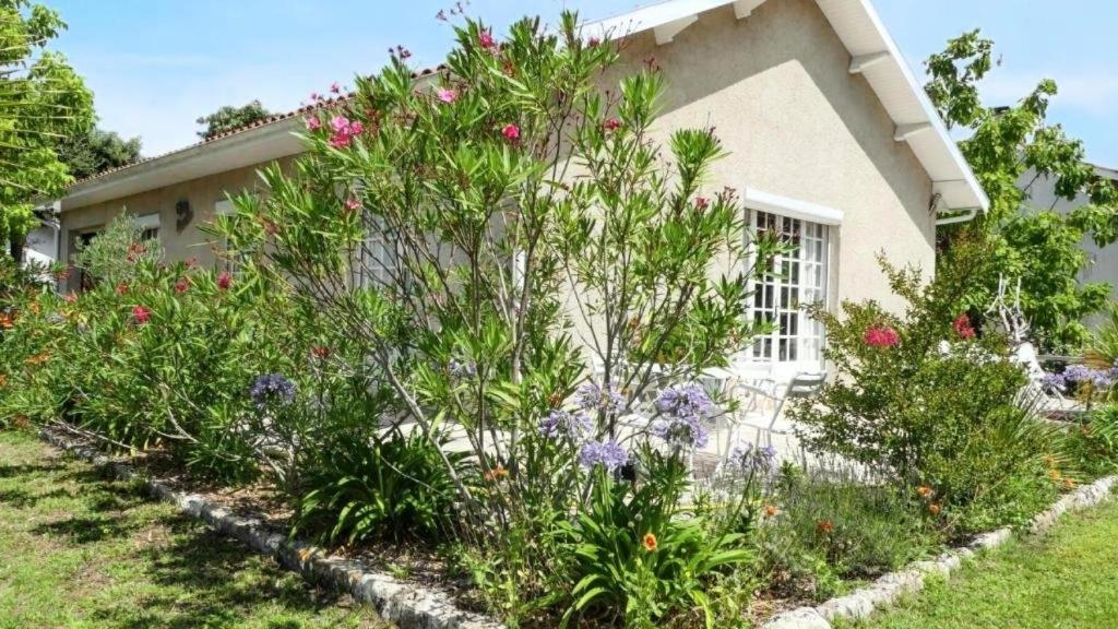 un jardin devant une maison avec des fleurs dans l'établissement Résidence 068-le Verdon Sur Mer - 068 - Maison familiale avec jardin au Verdon-sur-Mer MAE-4361, au Le Verdon-sur-Mer