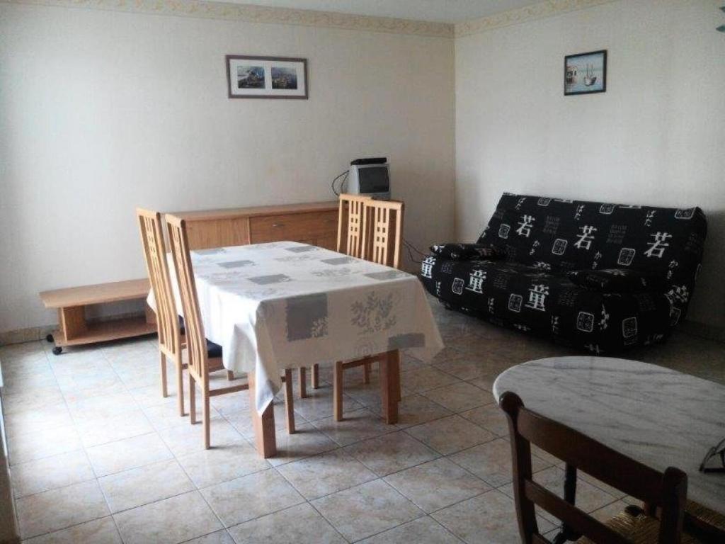 un salon avec une table, des chaises et un canapé dans l'établissement Résidence Villa Helios - SAINT MARC SUR MER 2 pièces centre-ville MAE-6281, à Géraud