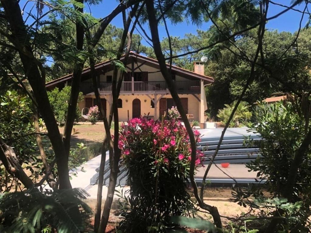 滨海苏拉克Résidence La Grande Combe - 009 - Magnifique villa avec piscine dans quartier résidentiel MAE-4501的前面有长凳和鲜花的房子