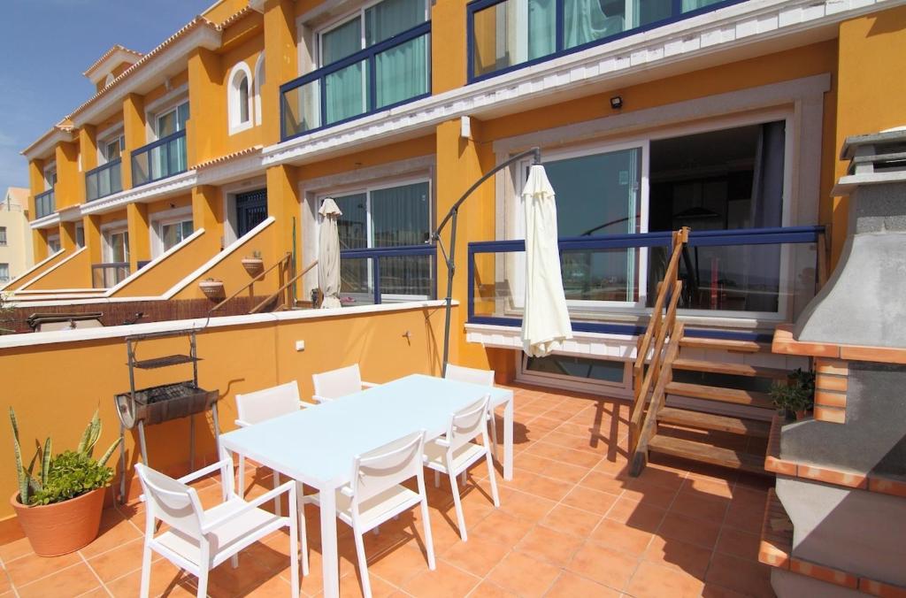 コティージョにあるAnju Villas Bravo Apartments Cotilloの白いテーブルと椅子付きのパティオ