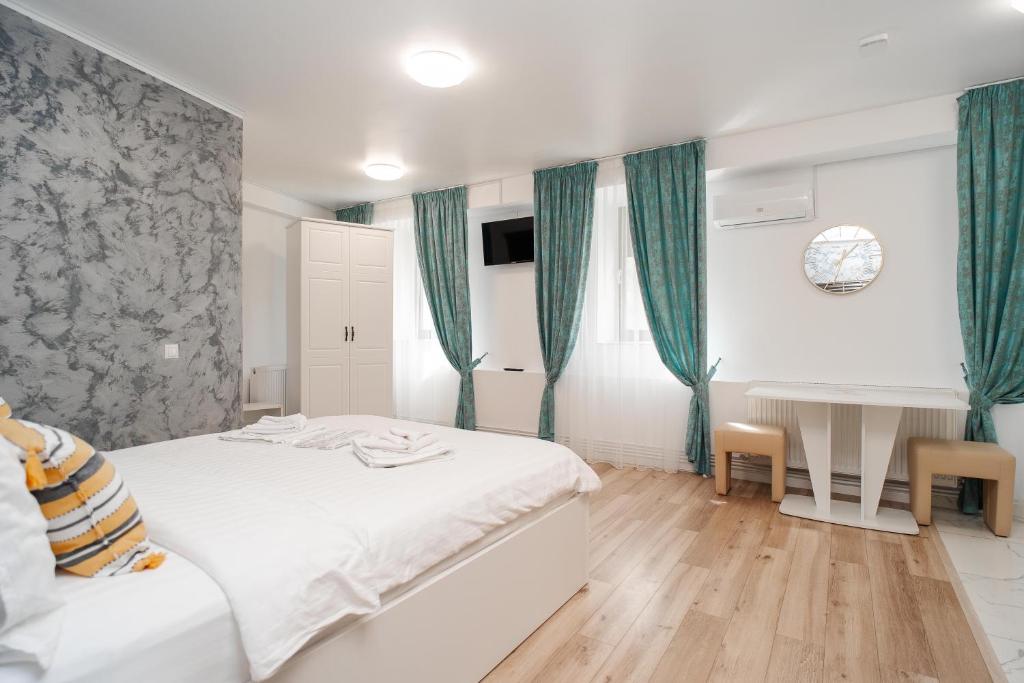 a bedroom with a bed and a desk in it at Grey Boutique Hotel Palas in Iaşi