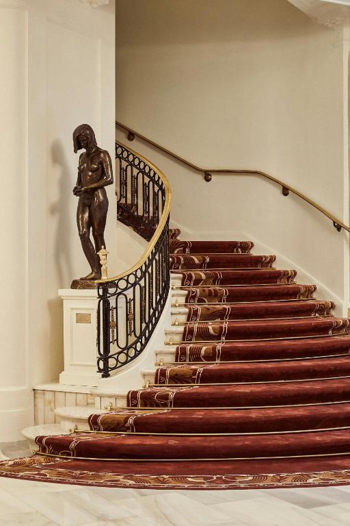 a staircase with a statue in a building at The Palace, a Luxury Collection Hotel, Madrid in Madrid