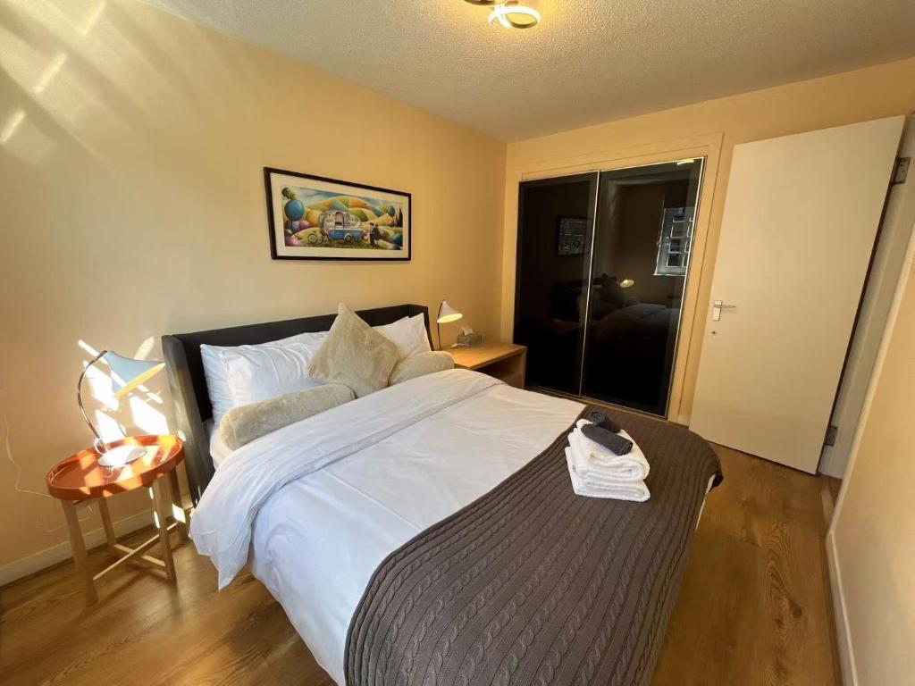 une chambre avec un grand lit avec des draps blancs dans l'établissement One room with parking space, à Édimbourg