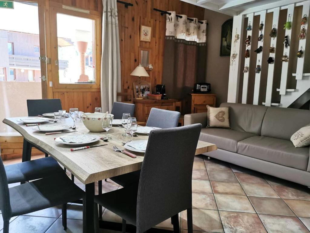 une salle à manger avec une table et un canapé dans l'établissement Résidence Bourg Morel - Le Bourg-Morel 3.5/2 - Grand duplex cosy, balcon plein sud MAE-7191, à Valmorel