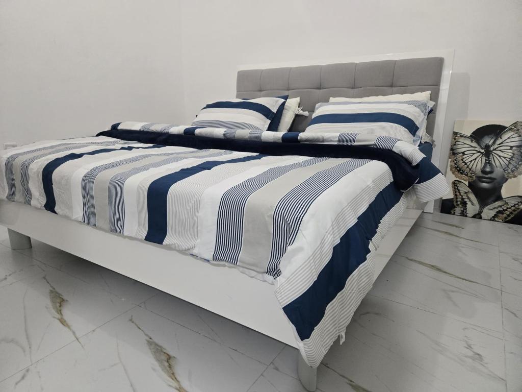 a bed with blue and white striped sheets and pillows at Luxury Home Studio in Abu Dhabi