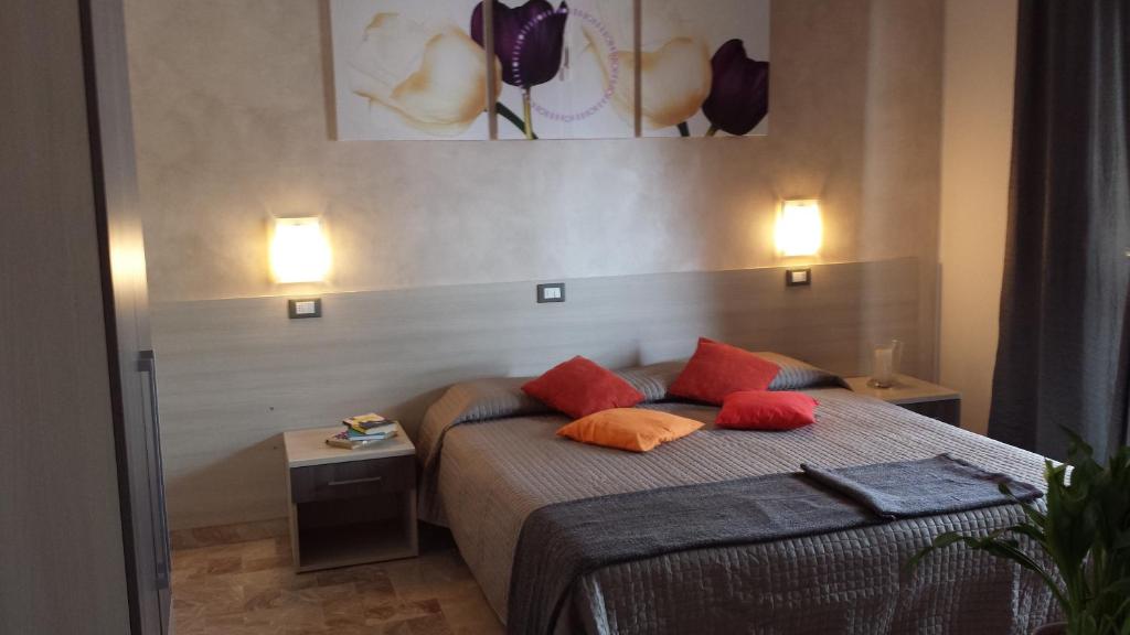 a bedroom with a bed with red pillows on it at B&B Monté in Montesilvano