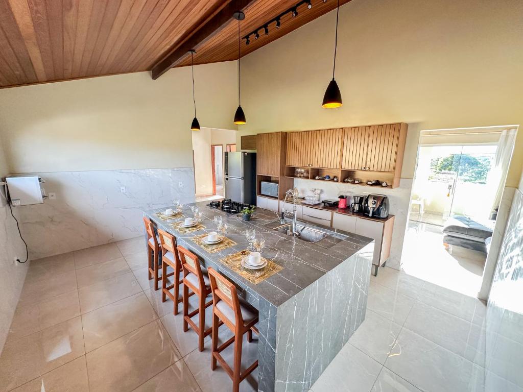 a kitchen with a island with a bar with chairs at Casa Superior Pedro Tavares in Búzios