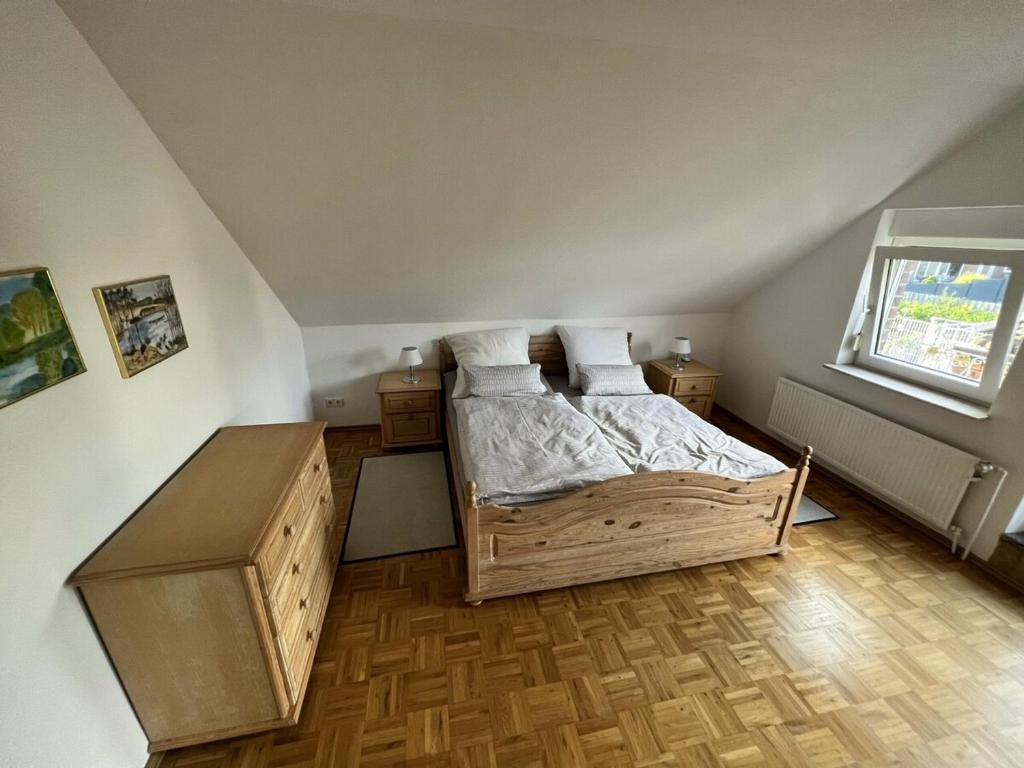 a bedroom with a wooden bed and a window at Großzügig in Rheine Eschendorf in Rheine