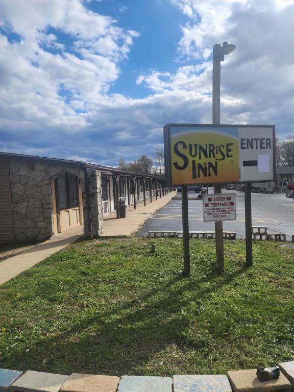 una señal para una posada al amanecer frente a un edificio en Sunrise Inn, en Elkton