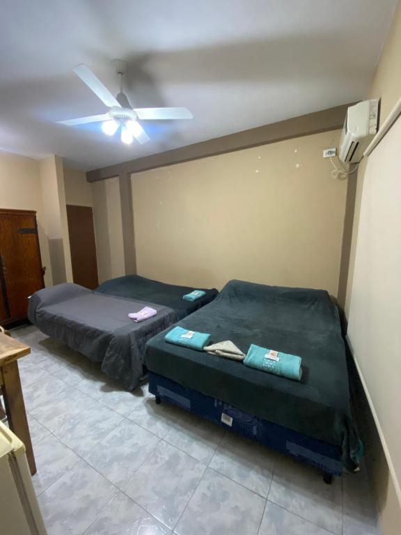 two beds in a room with a ceiling fan at LU DORMIS Alquiler Temporario in Corrientes