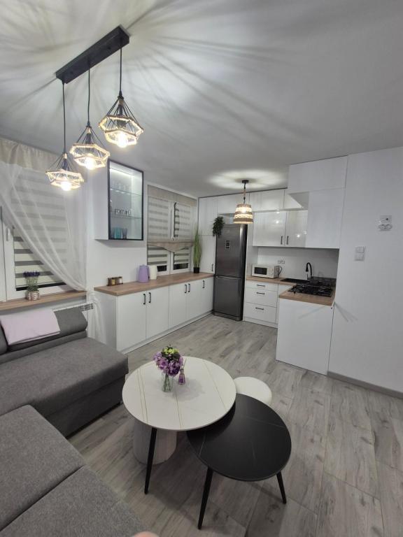 a living room and kitchen with a couch and a table at Lawendowy zakątek in Hrubieszów