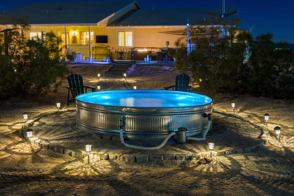 a hot tub with lights in a backyard at night at The Ranger Station plus Club House with Hot Tub in Joshua Tree