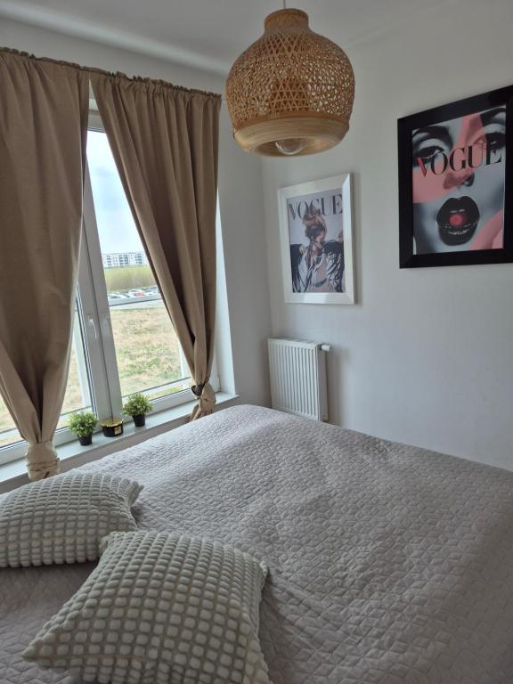una camera da letto con un letto e una grande finestra di Apartament Słoneczny Taras przy Aquapark Reda a Rumia