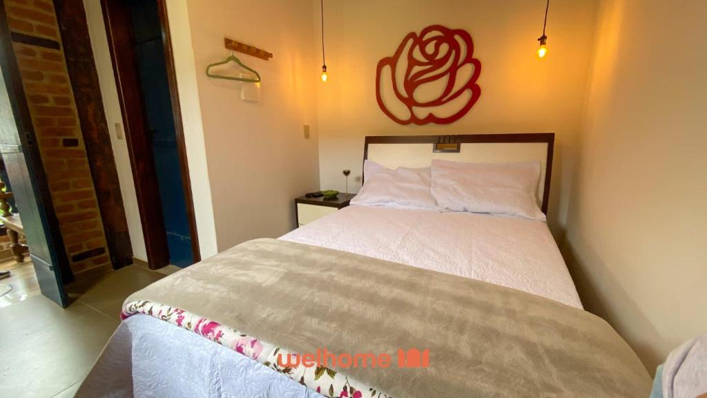 a bedroom with a bed with a red sign on the wall at Chale Rustico com Vista para a Montanha in Venda Nova do Imigrante