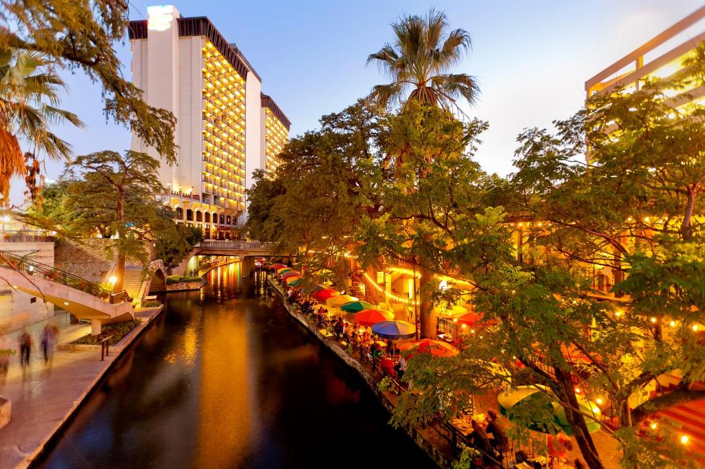 a river with umbrellas in a city at night at Hilton Palacio del Rio in San Antonio