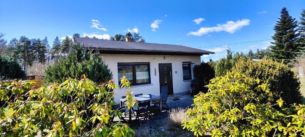 una piccola casa con un tavolo e sedie di fronte di Ferienhaus Im Wäldchen in See Nähe a Templin