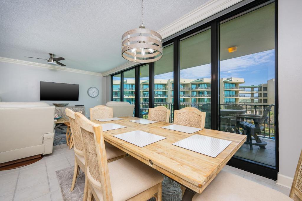 a dining room with a table with chairs and a television at Phoenix on the Bay 1310 condo in Orange Beach