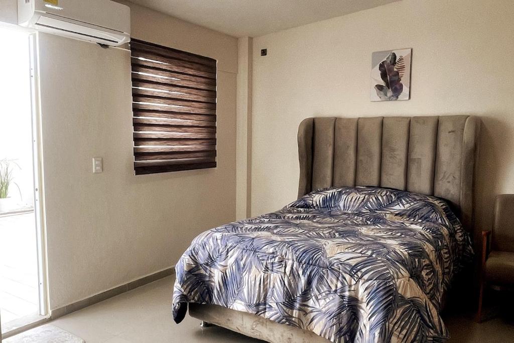 een slaapkamer met een bed in een kamer met een raam bij Centrico loft6 en Pto Vallarta in Puerto Vallarta
