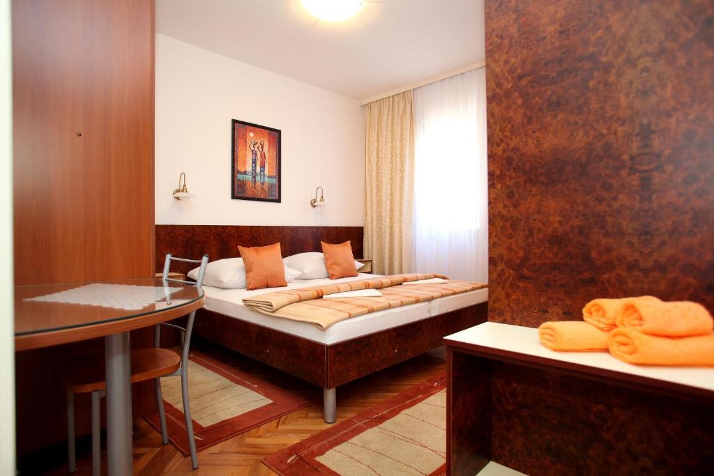 a hotel room with two beds and a desk at Apartment Ivan in Vinišće