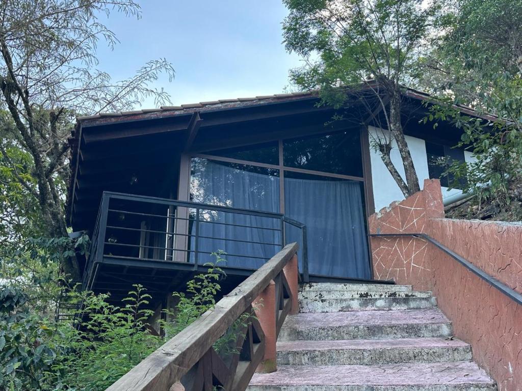 a house with stairs leading up to it at Cabaña de Vidrio en el Bosque in Pahuatlán del Valle