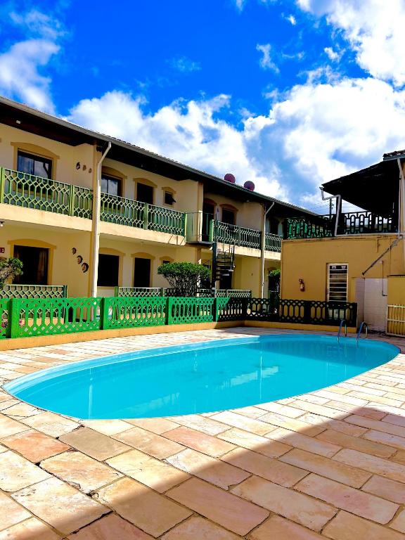 a swimming pool in front of a building at Apê Ubahê Maranduba Ubatuba in Ubatuba