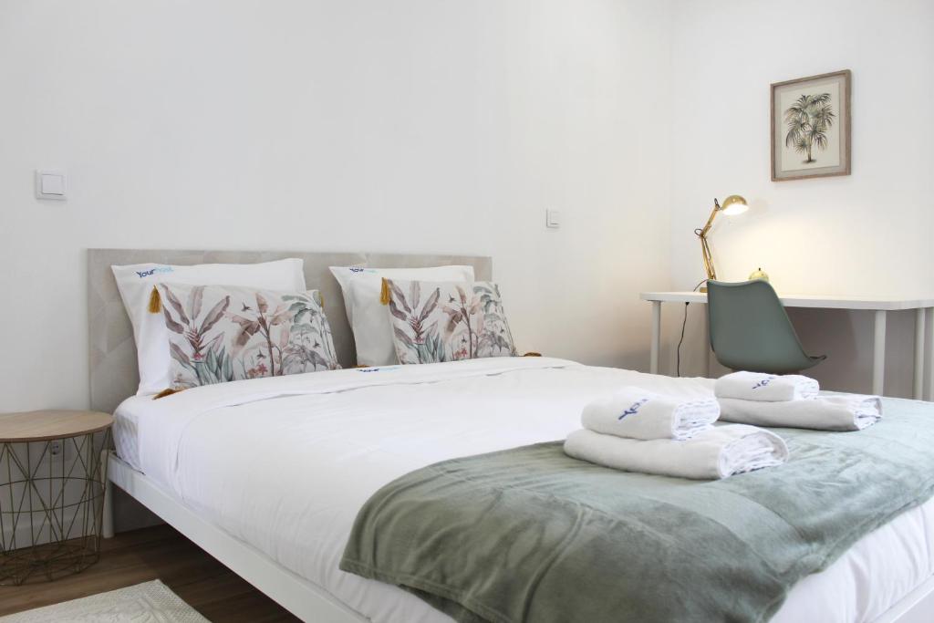 ein Schlafzimmer mit einem großen weißen Bett mit Handtüchern darauf in der Unterkunft Valbom Hideaway Light, Style and Peace in Valbom