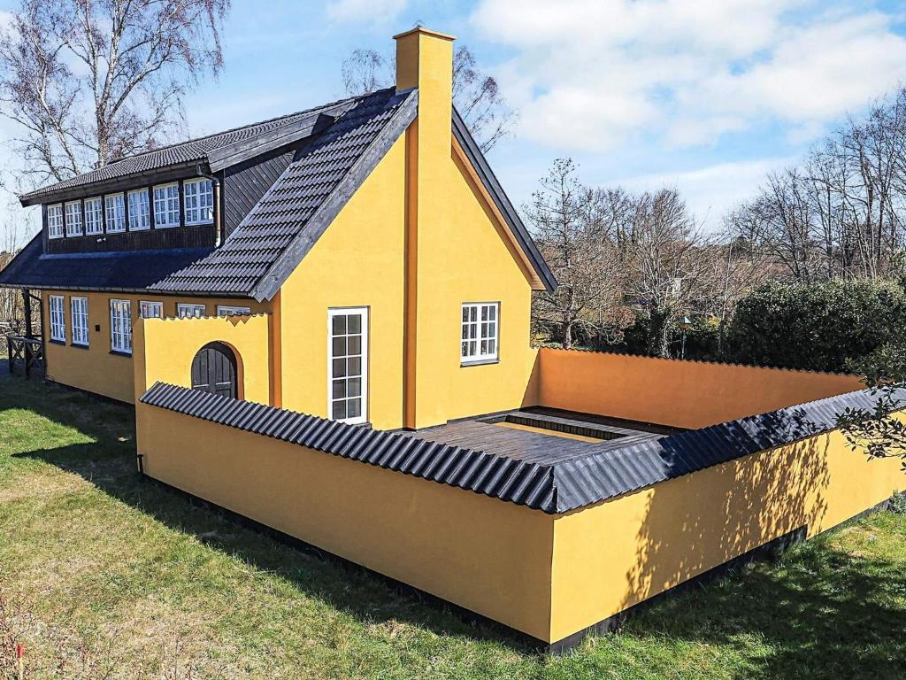 a yellow house with a solarium on the side of it at 5 star holiday home in Liseleje in Liseleje
