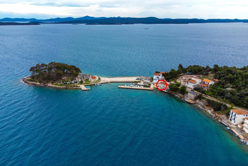 an island in the water with a red clock on it at Apartments by the sea Savar, Dugi otok - 23087 in Veli Rat