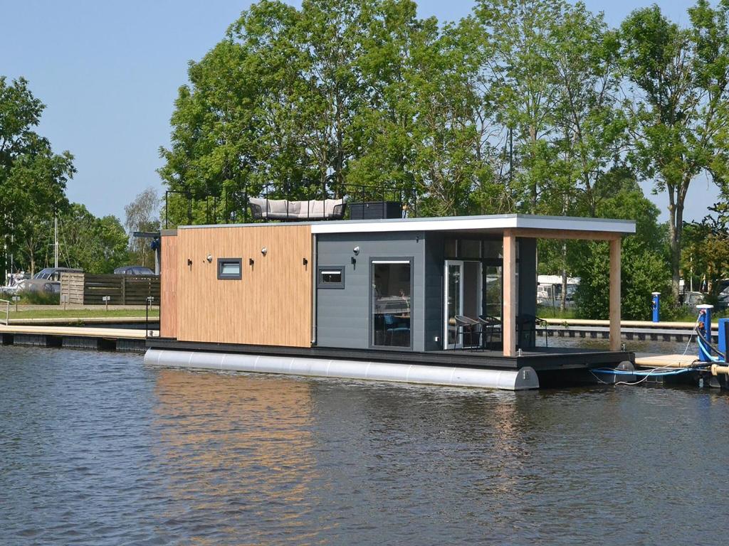 a tiny house on a dock on a body of water at Houseboat in Sneek with Lake Views in Offingawier