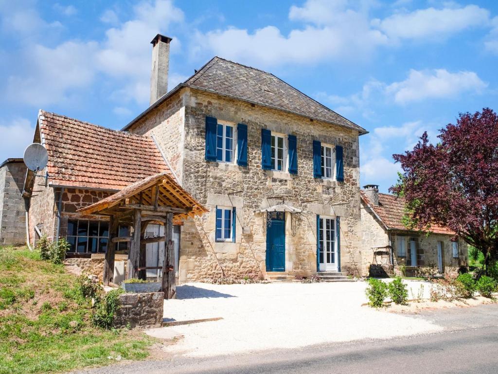 an old stone house with blue shutters on the side at Charming House in Coubjours with Pool in Coubjours