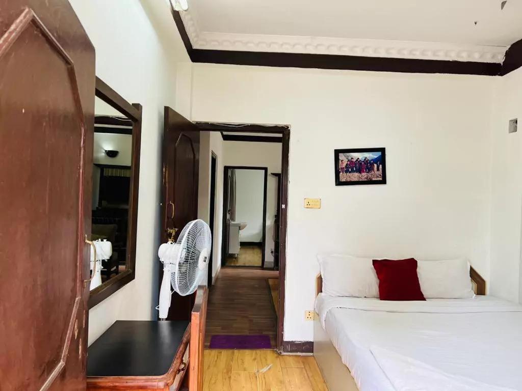 a small bedroom with a bed and a mirror at Nest apartment in Kathmandu