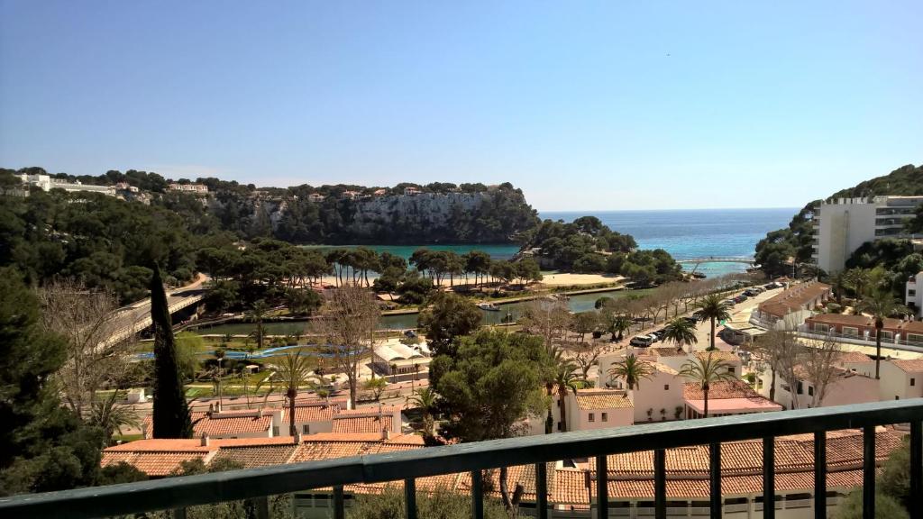 a view of a park with the ocean in the background at Apartamentos Encanto Del Mar in Cala Galdana