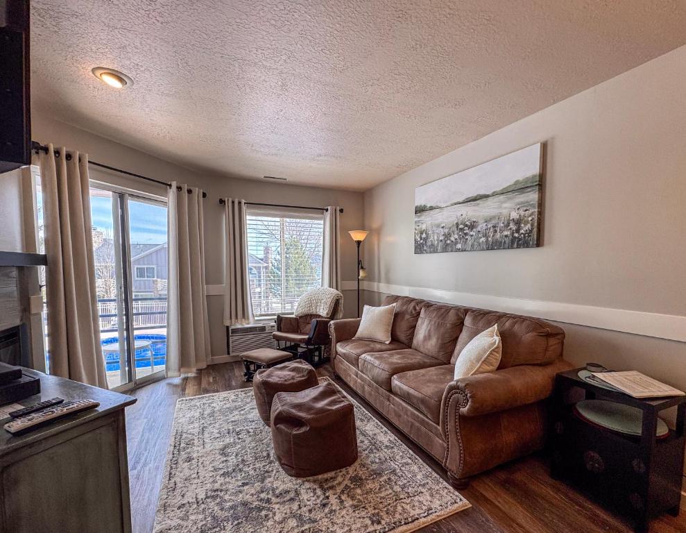 ein Wohnzimmer mit einer braunen Couch und einem großen Fenster in der Unterkunft Beautiful Inn Building Updated Condo 211 in Garden City