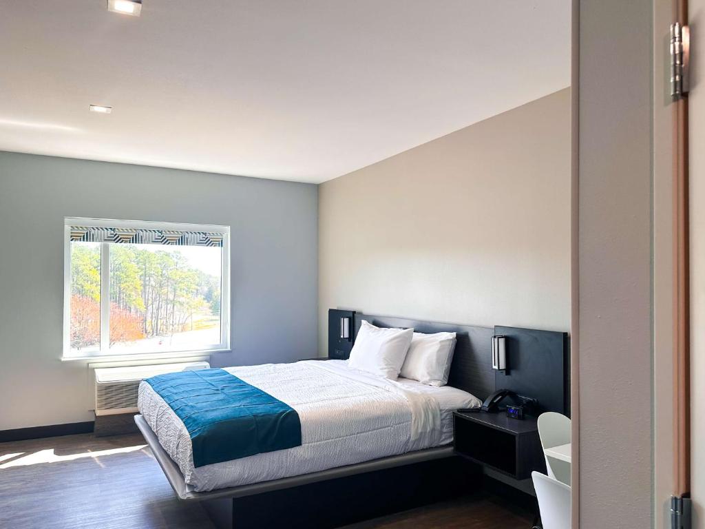 a bedroom with a bed and a window at Studio 6 Richmond Airport in Sandston