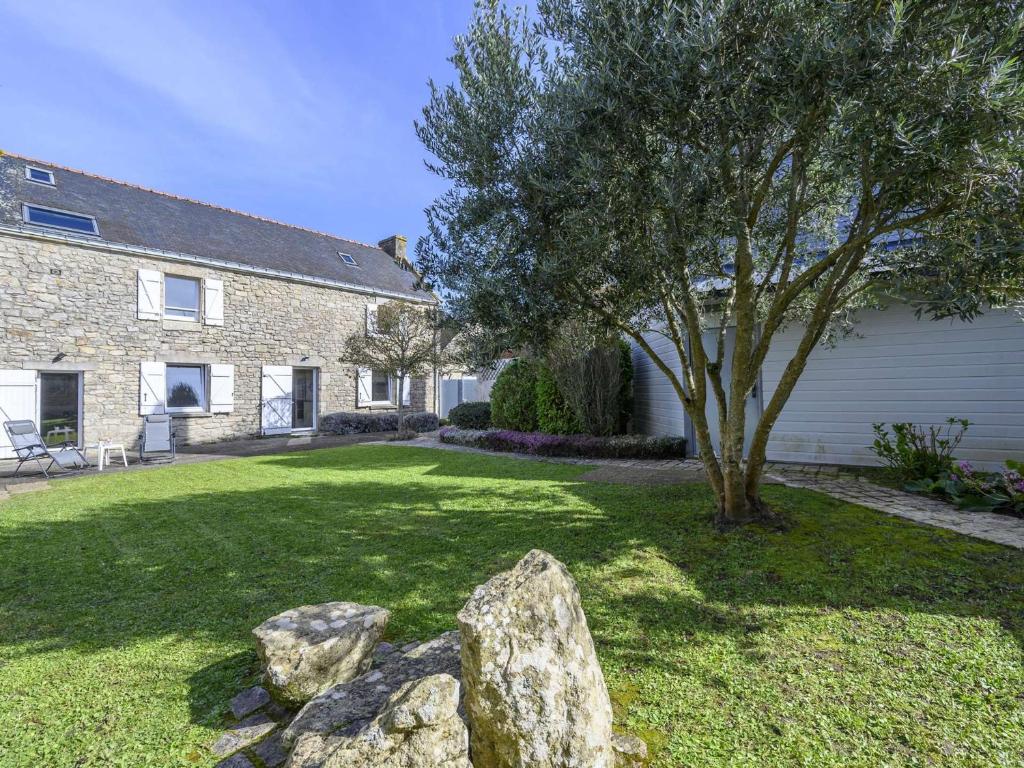 una casa de piedra con un árbol y un patio en Étel - Longère 7 pièces 150 m² - Wifi - Jardin clos - FR-1-479-225, en Étel