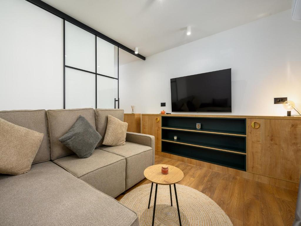 a living room with a couch and a tv at Room in Porec Old Town by Waterfront in Poreč