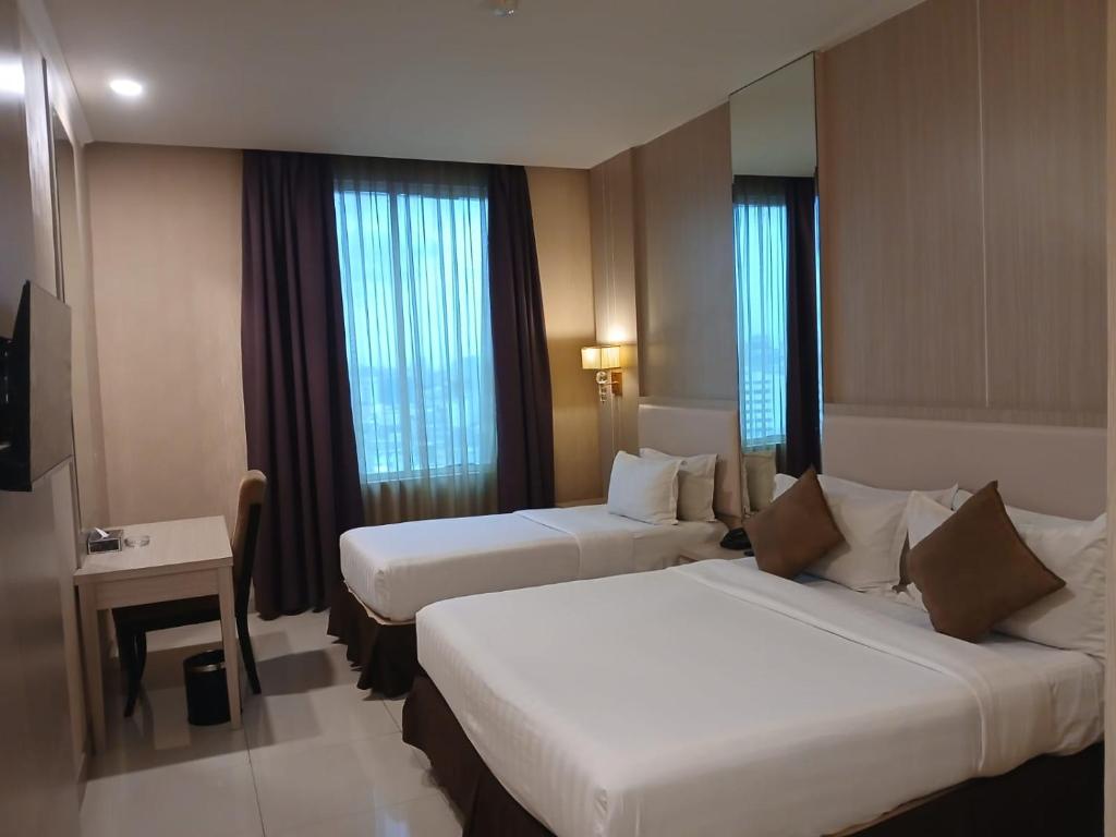 Postel nebo postele na pokoji v ubytování Grand Paragon Hotel